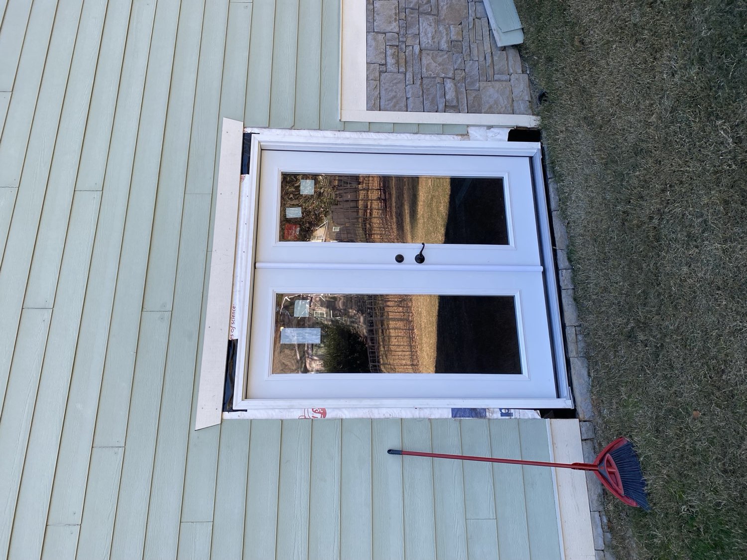 Exterior rebuild with new doors and stone veneer after property damage, by Top Rock Solutions